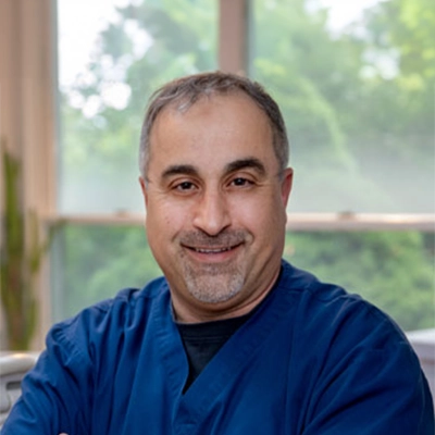 Dentist Ghazwan Ghazi Smiling In Blue Scrubs